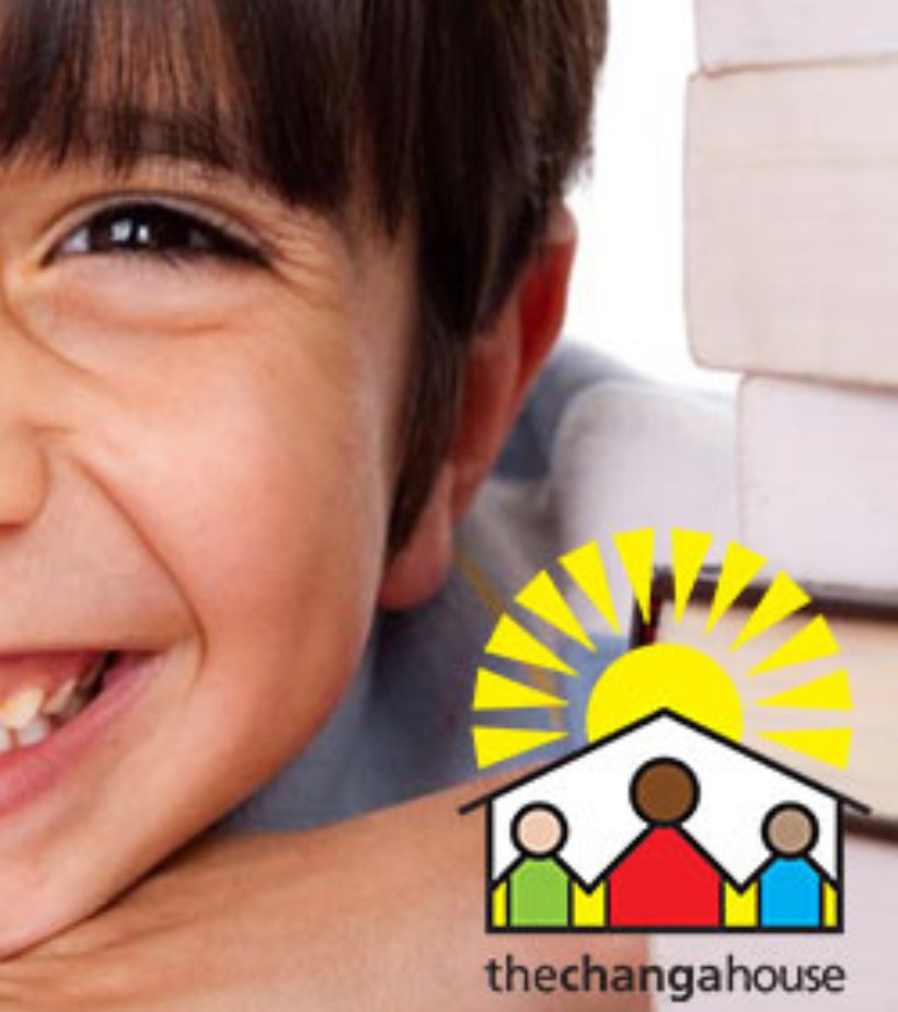 A smiling boy resting his chin on his hand, beside The Changa House logo.